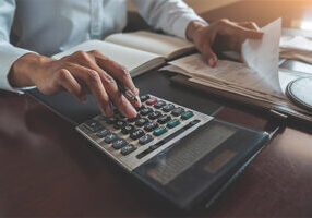 Lawyer at his desk calculating the value of a car accident settlement